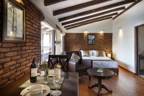 a living room with a couch and a brick wall at Hotel Patan House in Pātan