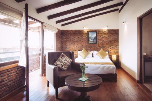 a bedroom with a bed and a chair and a table at Hotel Patan House in Pātan
