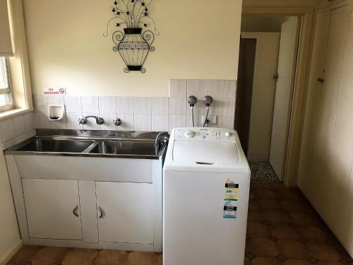 a small kitchen with a sink and a dishwasher at Admurraya House Bed & Breakfast in Rutherglen