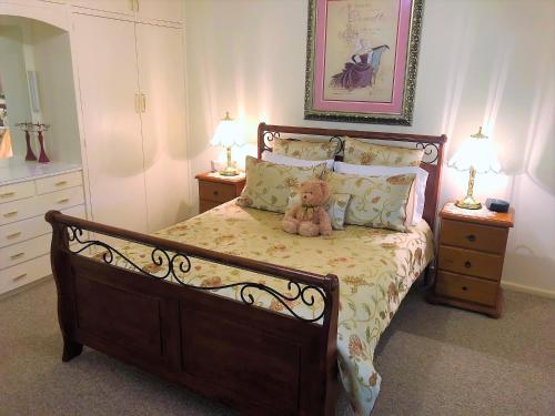 um urso de peluche sentado numa cama num quarto em Admurraya House Bed & Breakfast em Rutherglen