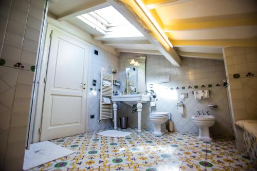 a bathroom with a toilet and a sink and a door at Relais Villa Al Vento in Incisa in Valdarno