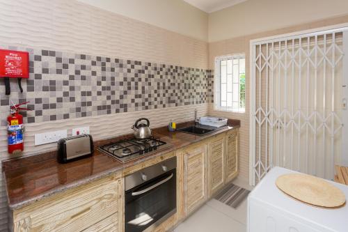 a kitchen with a stove and a counter top at Beau Vallon Villa Chalets in Beau Vallon