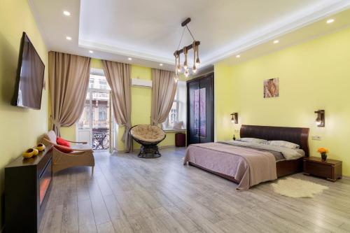 - une chambre avec des murs jaunes, un lit et une chaise dans l'établissement ViP apartment in ♥ of Lviv, à Lviv