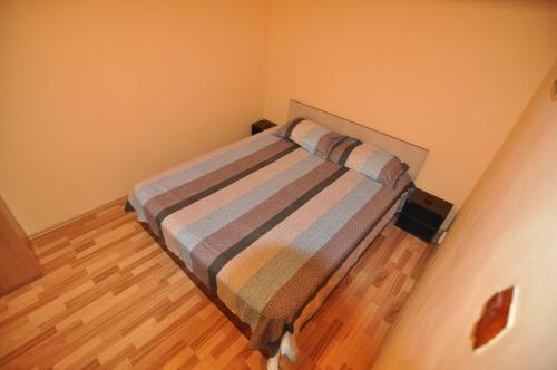 コンスタンツァにあるApartament Dobrilaのウッドフロアの小さな部屋の小さなベッド1台分です。