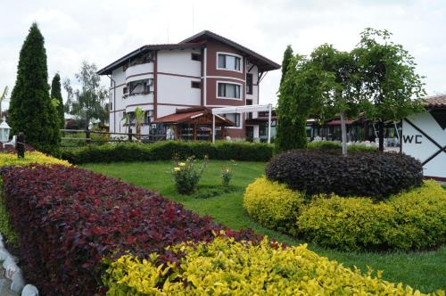 a house with a garden of flowers and bushes at Makaza Complex in Momchilgrad