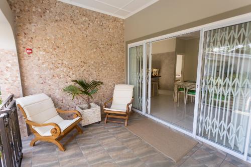 two chairs and a plant on a porch at Beau Vallon Villa Chalets in Beau Vallon