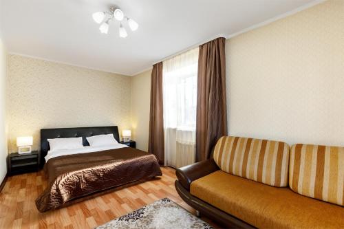 a hotel room with a bed and a couch at Апартаменты Авион Комфорт in Kemerovo