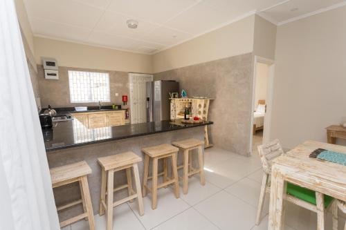 a kitchen with a counter and some stools in it at Beau Vallon Villa Chalets in Beau Vallon