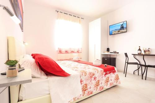 een slaapkamer met een bed, een tafel en een raam bij Rosso di Mare Alghero in Alghero