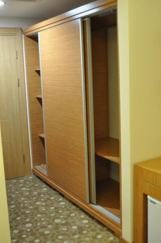 a closet with wooden doors in a room at Cebeciler Hotel in Trabzon