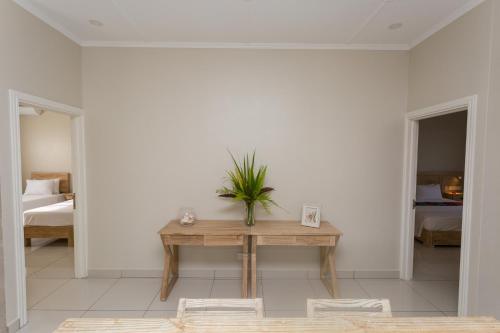 a room with a table with a plant on it at Beau Vallon Villa Chalets in Beau Vallon