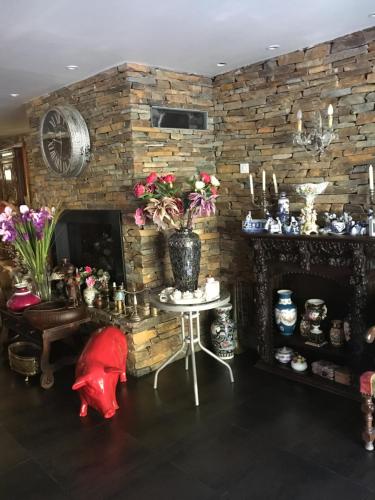 a room with a stone wall with a table with flowers at Hotel bar b'rock in Saint-Martin-sous-Vigouroux