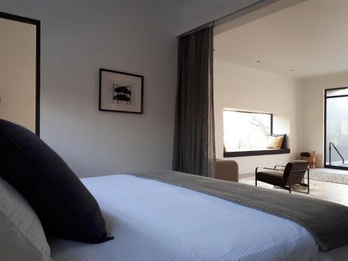 um quarto com uma cama e uma grande janela em Ochre House em Marloth Park