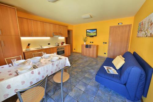 a kitchen with a dining table and a blue couch at Chalet Matteo in Livigno