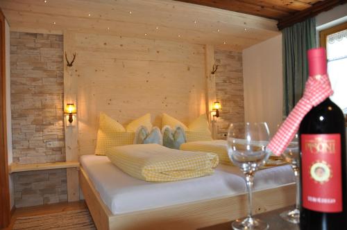 een kamer met een bed en een fles wijn bij Hotel Maroi in Wald am Arlberg