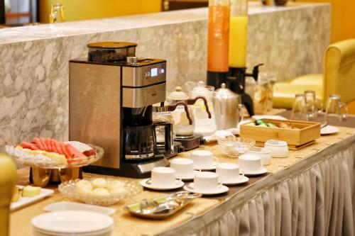 a kitchen with a coffee maker on a counter at Jinjiang Metropolo Hotel Hangzhou East Railway Station in Hangzhou