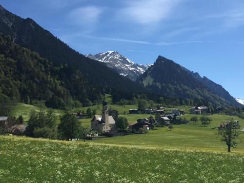 a village in a valley with mountains in the background at Hotel Maroi in Wald am Arlberg