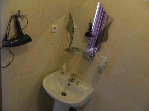 
a bathroom with a sink, toilet and mirror at Tsarevna Lyagushka Hotel in Rostov
