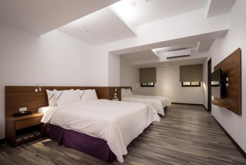 a hotel room with two beds and a tv at Xianghe Hotel in Mingjian