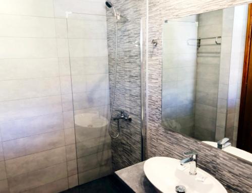 a bathroom with a sink and a shower with a mirror at Votsalakia Hotel in Marathokampos