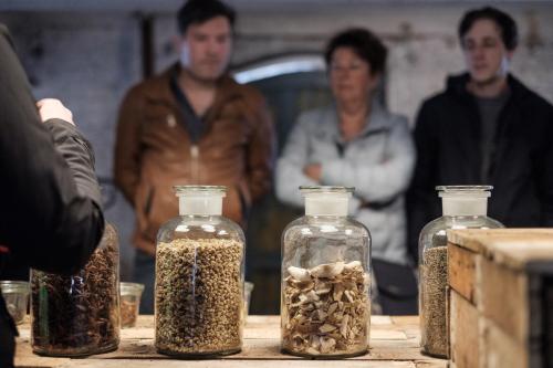 a group of people standing around glass jars filled with seeds at Hotel Brouwerij Het Anker in Mechelen