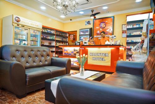 a barber shop with a leather chair and a couch at Ghazrin's Garuda Hotel in Johor Bahru