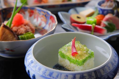 a bowl of food on a table with plates of food at Yufuin Bath Satoyamasafu in Yufu