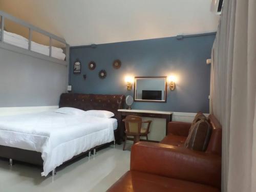 a bedroom with a bed and a desk and a chair at Baan JaoKorKluay บ้านเจ้ากอกล้วย in Chiang Rai