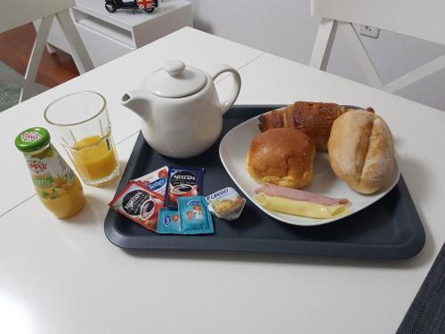 Five Design Rooftop by Storytellers في فونشال: صينية سوداء عليها طبق طعام وإبريق شاي