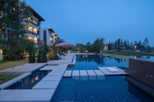 a swimming pool in front of a building at Green Ville Laguna Hotel in Sung Noen
