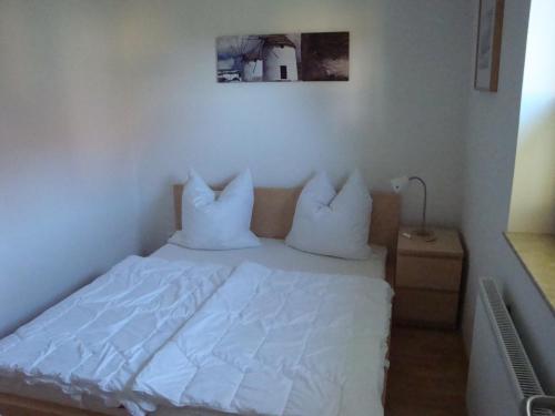 リーブニッツ・ダムガルテンにあるAm Waldessaum 10のベッド(白いシーツ、枕付)