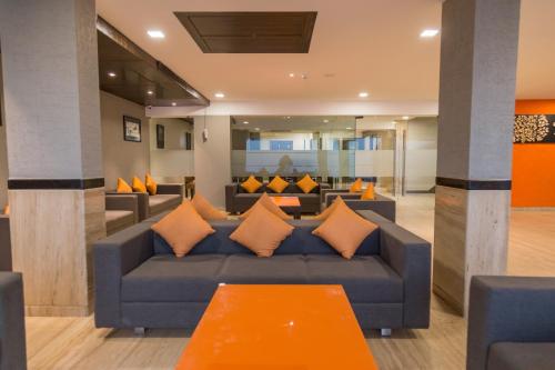 a living room with a blue couch with orange pillows at Ginger Ahmedabad, Satellite in Ahmedabad