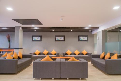 a living room with couches and orange pillows at Ginger Ahmedabad, Satellite in Ahmedabad