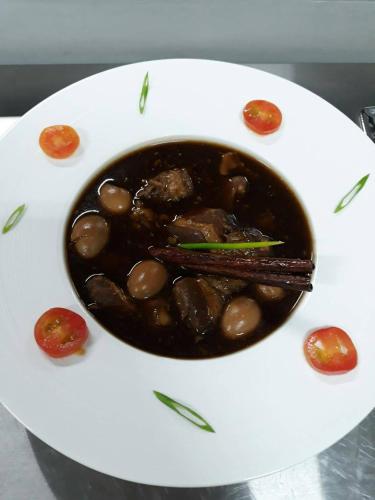 a bowl of food on a plate with beans at Green Ville Laguna Hotel in Sung Noen