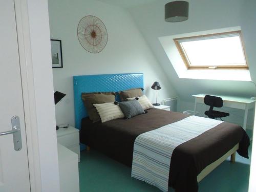 - une chambre avec un lit doté d'une tête de lit bleue et d'une fenêtre dans l'établissement Au calme, avec jardin et proches des sites touristiques, à Vannes