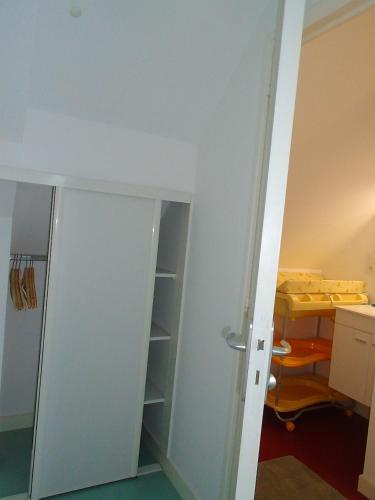 Cette chambre comprend un placard avec une porte et un bureau. dans l'établissement Au calme, avec jardin et proches des sites touristiques, à Vannes