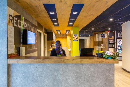 a woman sitting at a counter in an office at ibis budget Paris Clichy Mairie in Clichy