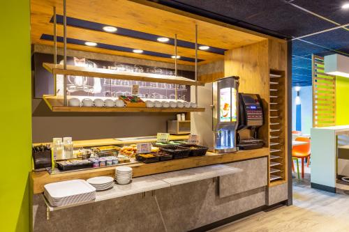 a fast food restaurant with a counter with food at ibis budget Paris Clichy Mairie in Clichy