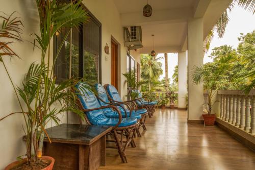 a hallway with chairs and plants in a house at Crystall Goa Palolem in Palolem