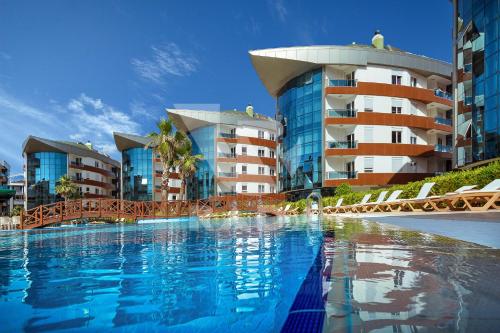 a large swimming pool in front of some buildings at Onkel Rada Apart Hotel in Antalya