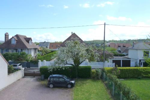 a car parked in a driveway in a yard at Studio proche du centre ville et de la plage in Villers-sur-Mer