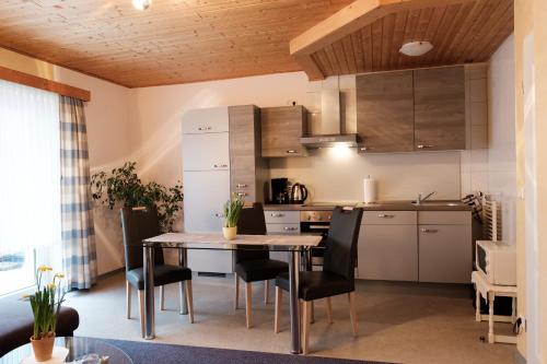 a kitchen and dining room with a table and chairs at Ferienwohnungen Hasenpatt in Bad Sachsa