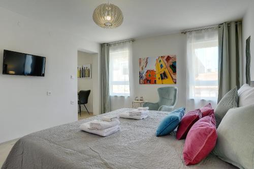 a bedroom with a bed with towels on it at D&A Amphitheatre Apartments with free parking in Pula