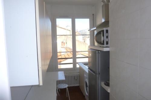 une petite cuisine avec un four micro-ondes et une fenêtre dans l'établissement Appart 2 pièces prés plage Mourillon Toulon, à Toulon