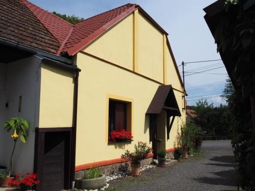 a small yellow house with a red roof at Penzion Bližanovy in Plánice