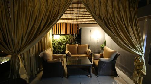 a balcony with chairs and a table and curtains at Hotel City Heart Premium in Chandīgarh