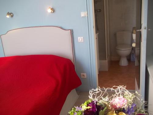 聖讓萊托馬的住宿－迪恩斯別墅住宿加早餐旅館，一间卧室配有一张带红色毯子和鲜花的床