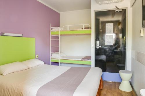 a bedroom with a bed and two bunk beds at Hotel Valence Sud in Portes-lès-Valence