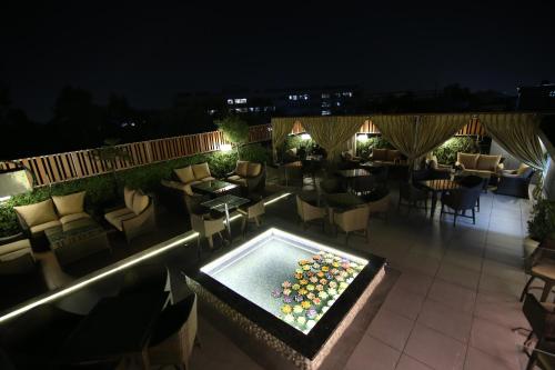 a rooftop patio with a pool and tables and chairs at Hotel City Heart Premium in Chandīgarh