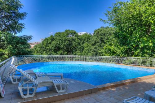 una piscina con sillas y una valla alrededor en Hotel Erma, en Golden Sands